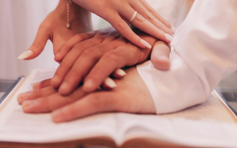 a group of people putting their hands on top of a book